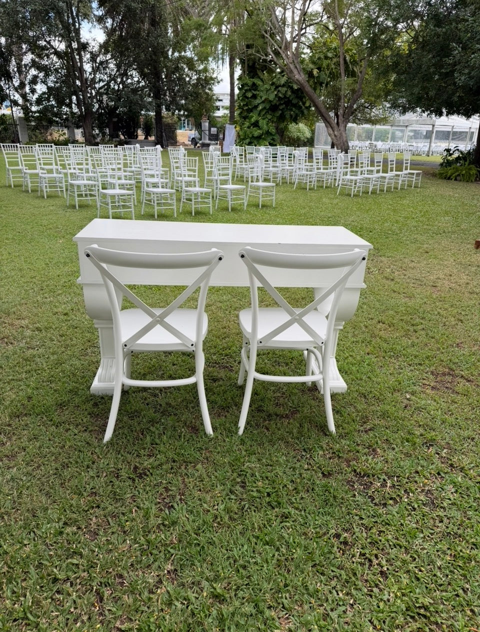 French Provincial or Hamptons-style white signing table with impressive pedestal legs & drawers. Pair with white cross back chairs.  Wedding, event & party hire.  Rockhampton Vintage Hire 